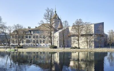 The Swiss National Museum in Zurich overlooking the Limmat river on a clear day.